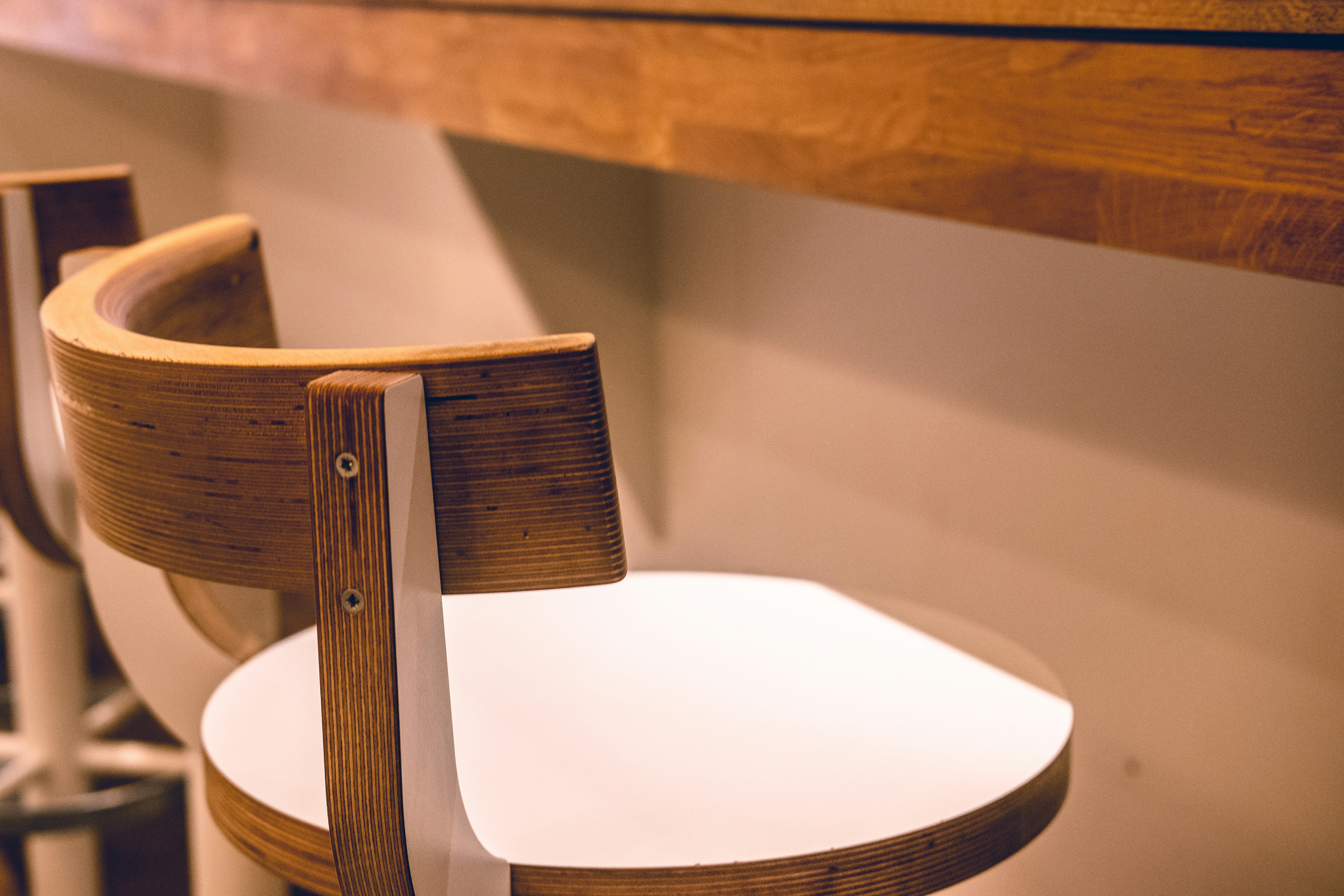 A clean, wide-angle shot of a modern cafeteria with stackable, molded plastic chairs neatly pushed under laminate tables